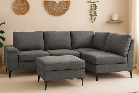 Divano angolare 4/5 posti in tessuto ciniglia grigio antracite con pouf e vano contenitore Colchester foto ambientata