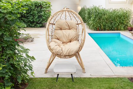 set da esterno con poltrona su gambe effetto rattan e poggiapiedi con cuscino beige rettangolare concept u